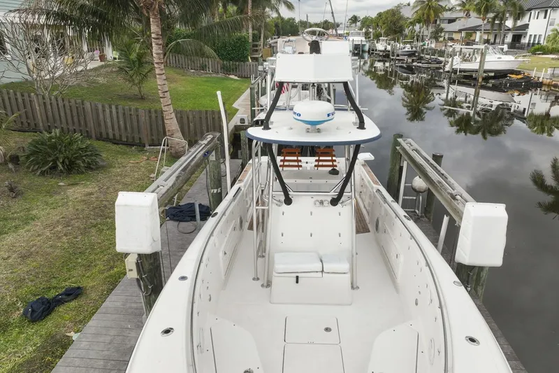 Slide: The Image of 2007 Triton 351 CC boat docked by a canal with lush greenery. - 11
