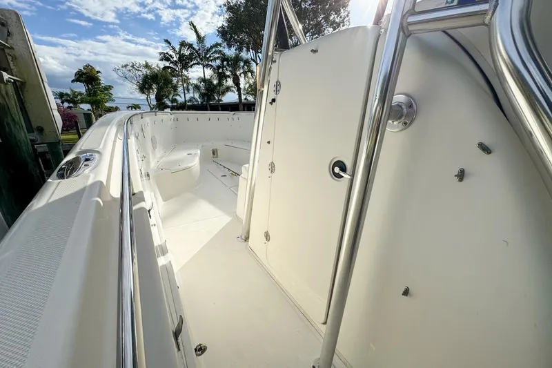 Slide: The Image of 2007 Triton 351 CC boat interior with stainless steel railings and seating, under a blue sky. - 112