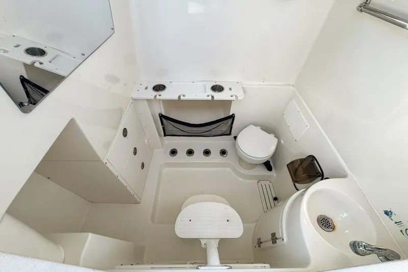 Slide: The Image of 2007 Triton 351 CC boat interior with compact bathroom and storage features. - 115