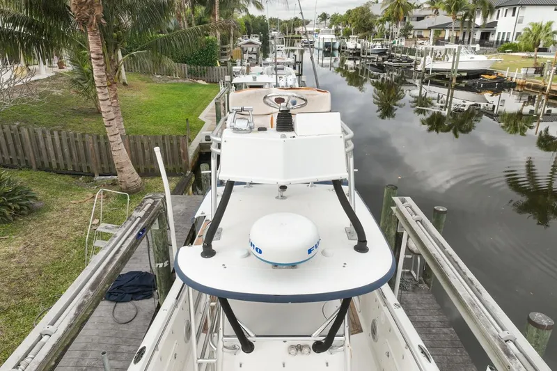 Slide: The Image of 2007 Triton 351 CC boat docked in a scenic canal with palm trees. - 12