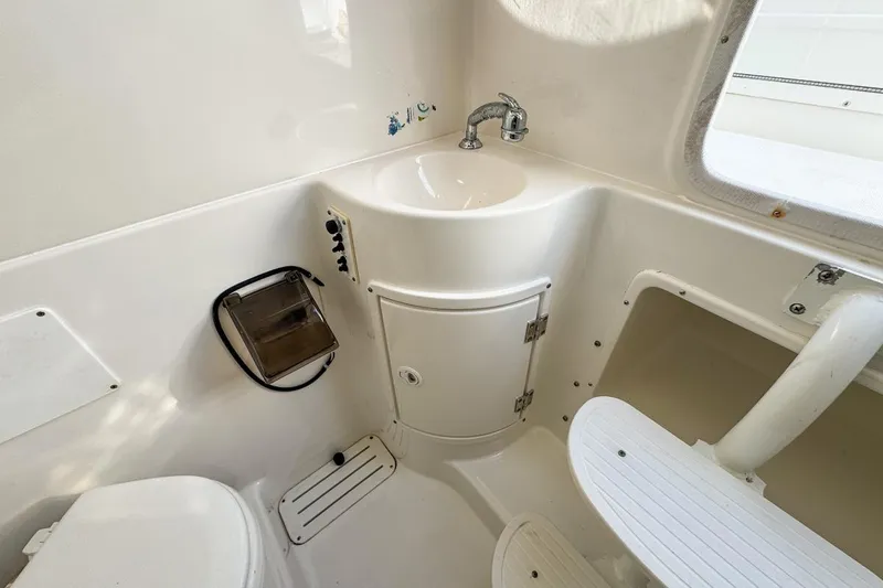 Slide: The Image of 2007 Triton 351 CC boat bathroom with sink, toilet, and storage. - 121