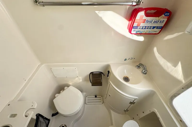 Slide: The Image of 2007 Triton 351 CC boat bathroom with toilet, sink, and first aid kit. - 123