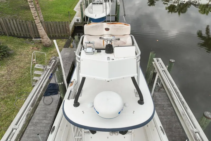 Slide: The Image of 2007 Triton 351 CC boat docked by a wooden pier, surrounded by calm water. - 124