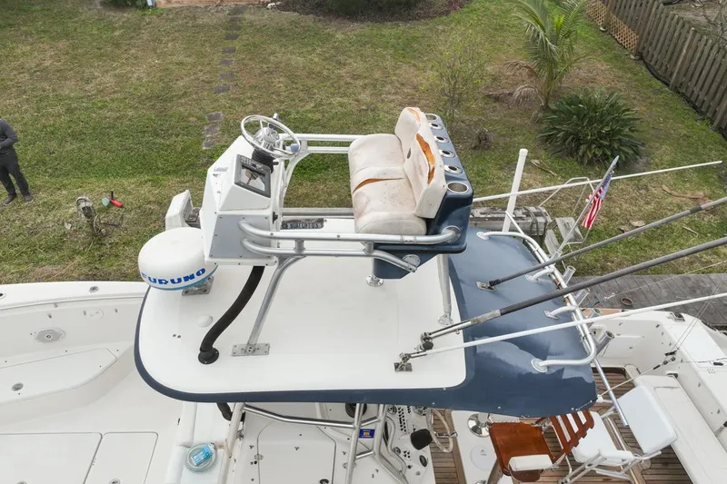 Slide: The Image of 2007 Triton 351 CC boat with elevated helm, fishing rods, and American flag. - 126