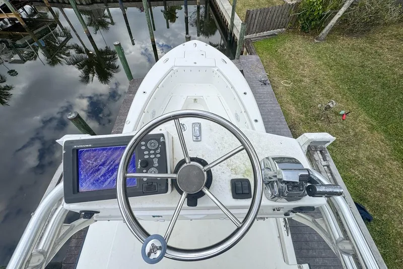 Slide: The Image of Top view of 2007 Triton 351 CC boat helm with steering wheel and navigation system. - 128