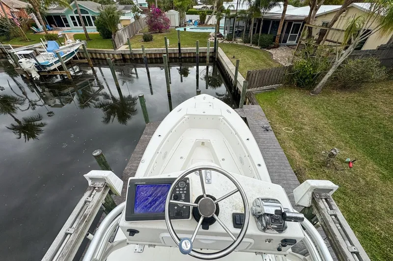 Slide: The Image of 2007 Triton 351 CC boat docked in a residential canal setting. - 130