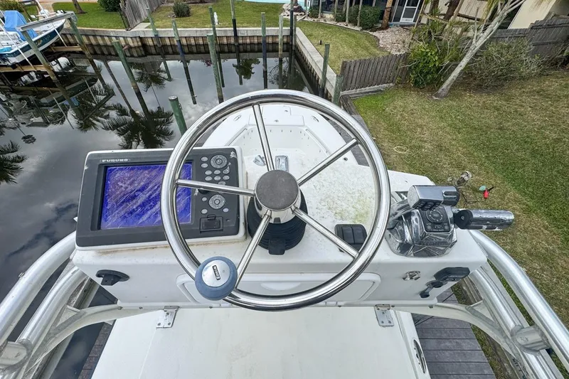 Slide: The Image of 2007 Triton 351 CC boat helm with steering wheel and navigation system. - 131