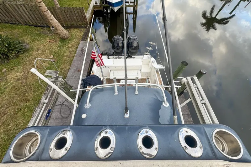 Slide: The Image of 2007 Triton 351 CC boat docked, aerial view showing deck and dual engines. - 132