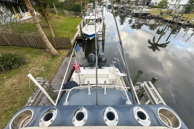 Slide: The Image of 2007 Triton 351 CC boat docked in a serene canal setting with palm trees. - 134