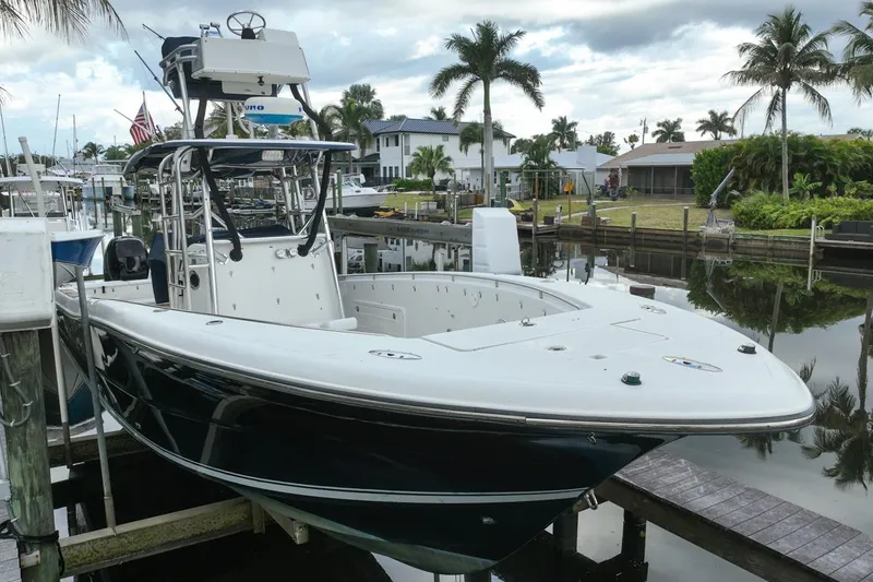 Slide: The Image of 2007 Triton 351 CC boat docked in a scenic marina with palm trees. - 16