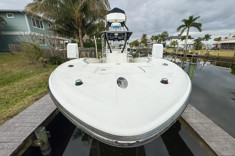 Slide: The Image of 2007 Triton 351 CC boat docked near palm trees and waterfront homes. - 19