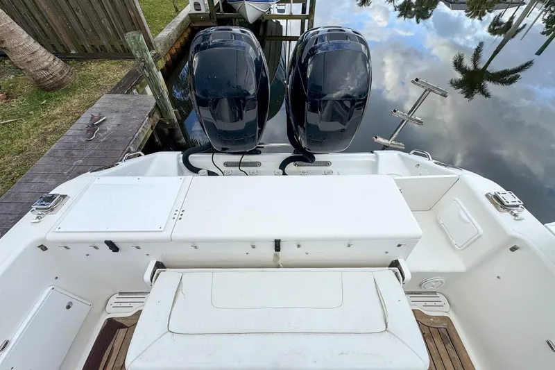 Slide: The Image of 2007 Triton 351 CC boat with dual outboard motors docked by wooden pier. - 25