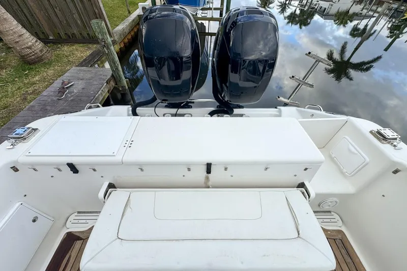 Slide: The Image of 2007 Triton 351 CC boat with dual outboard motors docked by a wooden pier. - 26