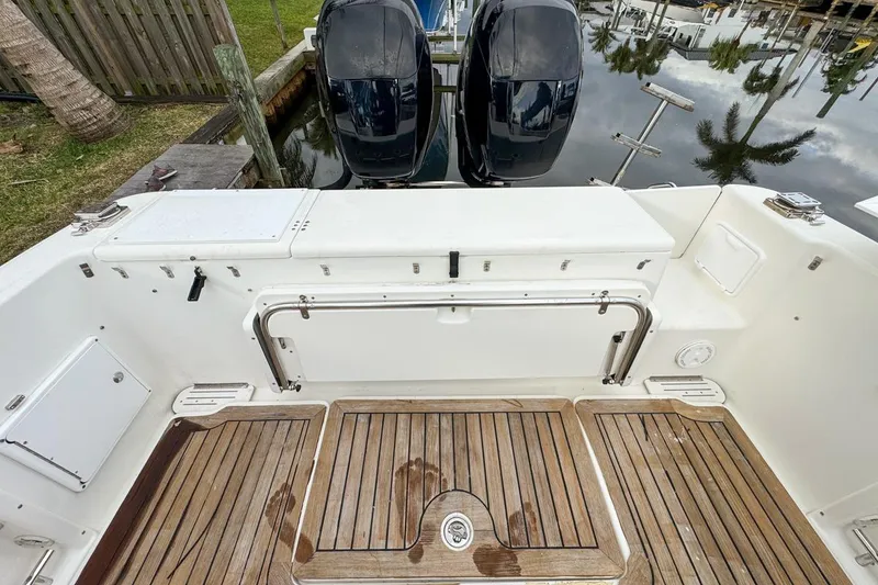 Slide: The Image of 2007 Triton 351 CC boat deck with twin outboard motors and wooden flooring. - 31