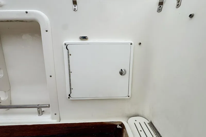 Slide: The Image of 2007 Triton 351 CC boat interior with white storage compartment and metal fixtures. - 35