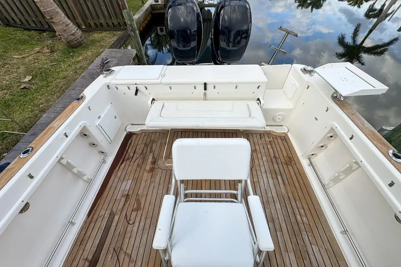 Slide: The Image of 2007 Triton 351 CC boat with wooden deck and seating, docked by the water. - 38