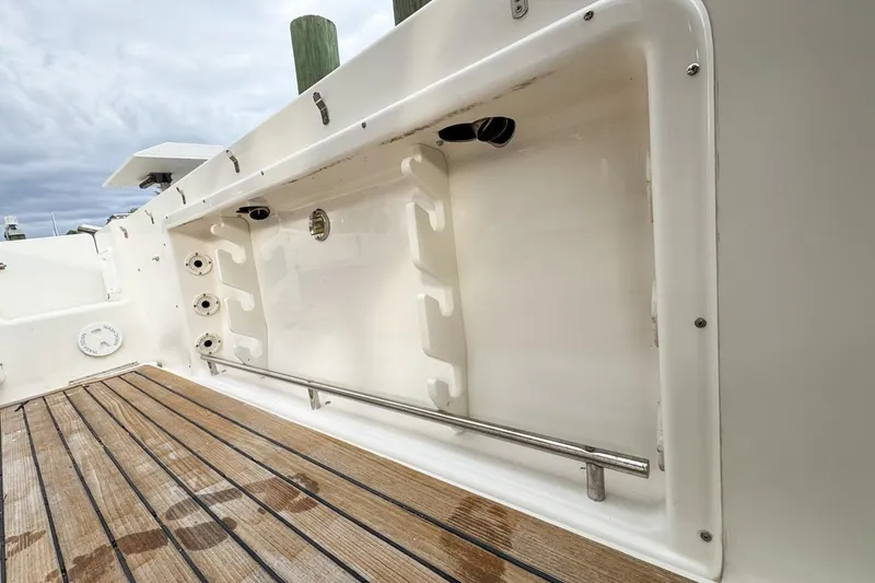 Slide: The Image of 2007 Triton 351 CC boat interior with wooden deck and storage compartment. - 47