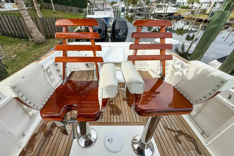 Slide: The Image of 2007 Triton 351 CC boat with wooden fishing chairs and white cushions on deck. - 48