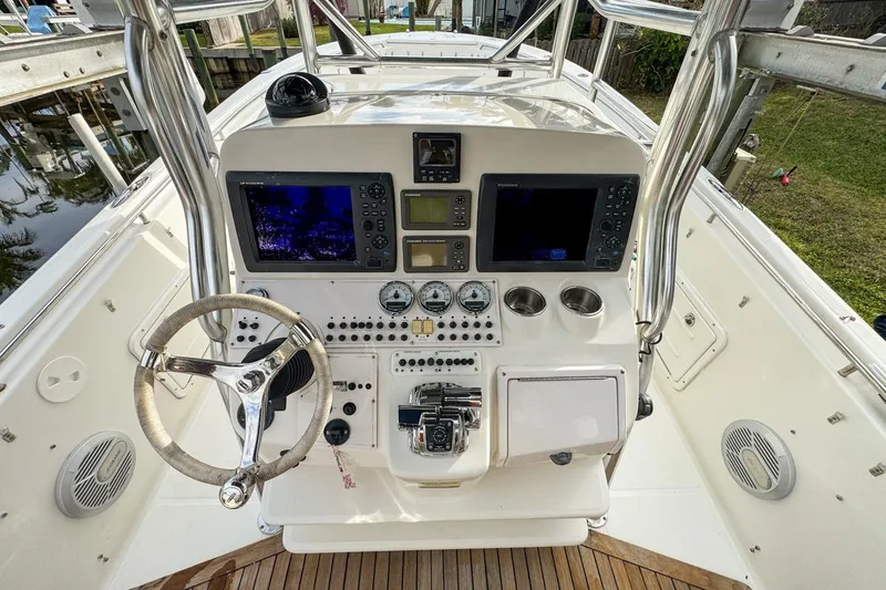 Slide: The Image of 2007 Triton 351 CC boat console with steering wheel, navigation screens, and control panel. - 52