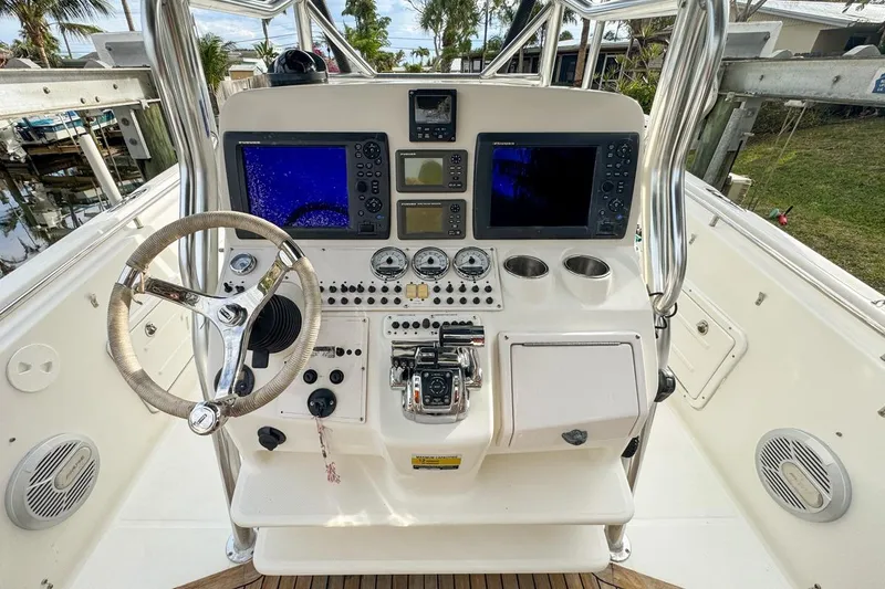Slide: The Image of 2007 Triton 351 CC boat dashboard with steering wheel, navigation screens, and control panel. - 53
