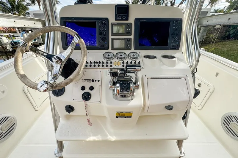 Slide: The Image of 2007 Triton 351 CC boat console with steering wheel, gauges, and navigation screens. - 54