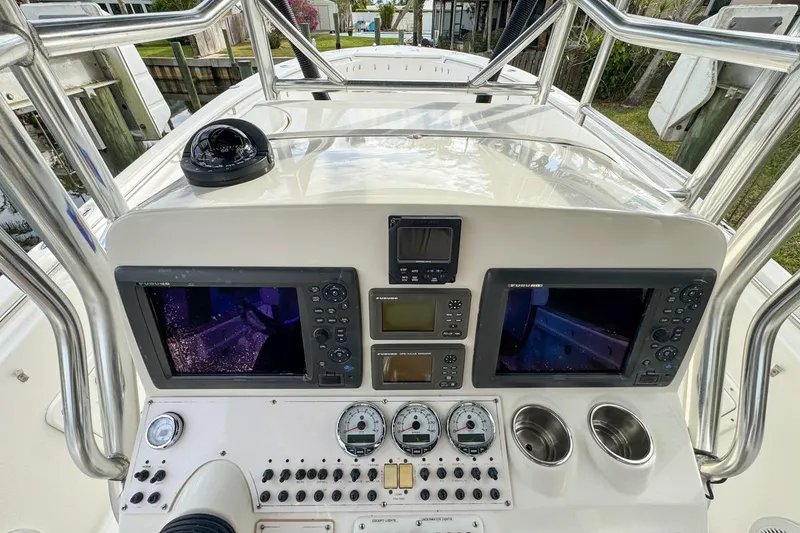Slide: The Image of 2007 Triton 351 CC boat dashboard with navigation screens and controls. - 57