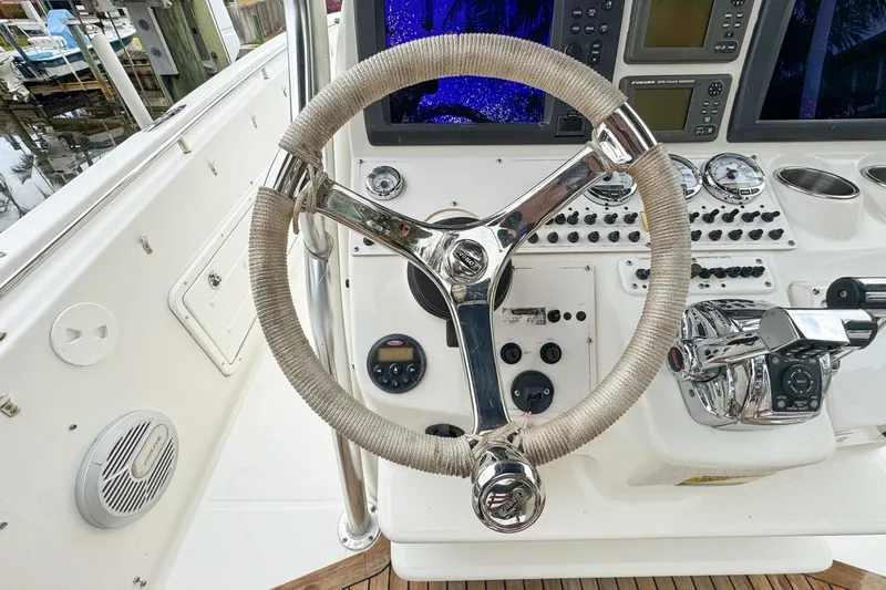 Slide: The Image of Steering wheel and controls of a 2007 Triton 351 CC boat cockpit. - 59