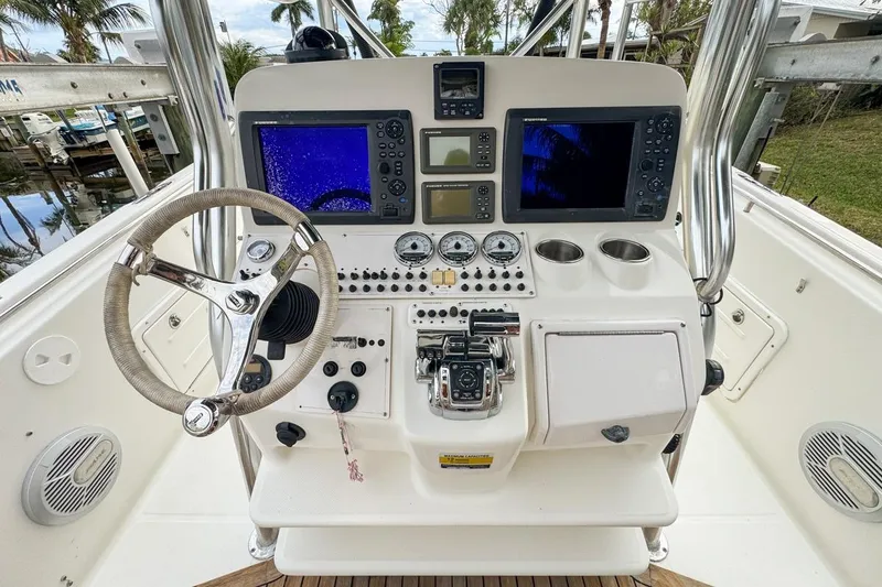 Slide: The Image of Control panel of a 2007 Triton 351 CC boat with navigation screens and steering wheel. - 64