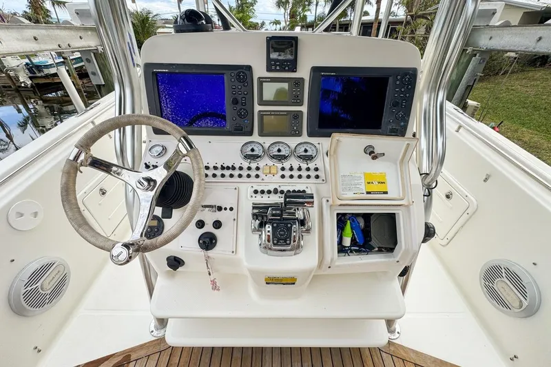 Slide: The Image of 2007 Triton 351 CC boat dashboard with steering wheel, navigation screens, and control panel. - 65