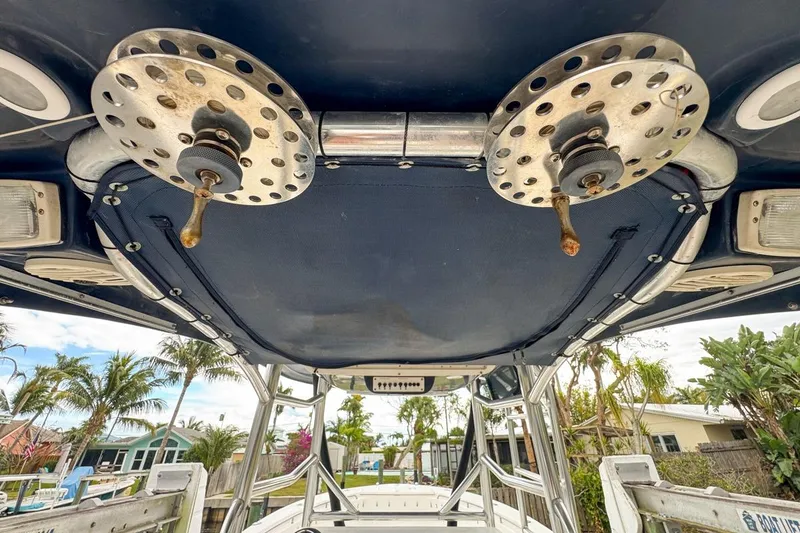 Slide: The Image of Triton 351 CC 2007 boat interior with rod holders and canopy, surrounded by tropical scenery. - 67