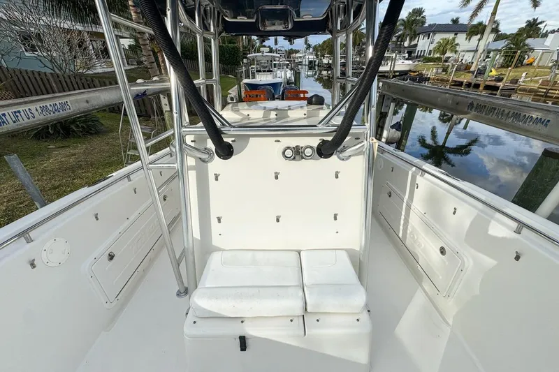 Slide: The Image of 2007 Triton 351 CC boat interior with seating and storage, docked by a canal. - 74