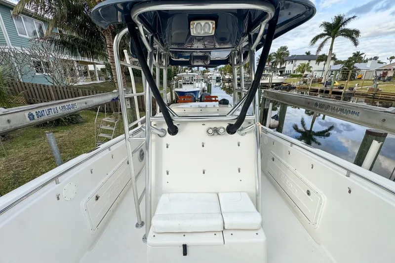 Slide: The Image of 2007 Triton 351 CC boat interior with seating, docked near waterfront homes. - 75