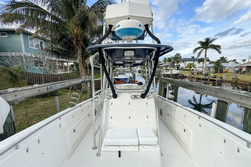 Slide: The Image of 2007 Triton 351 CC boat docked, surrounded by palm trees and waterfront homes. - 76