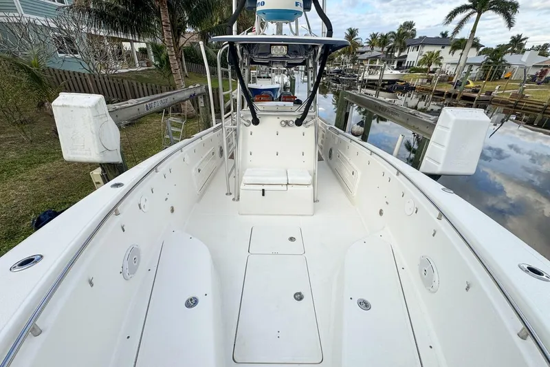 Slide: The Image of 2007 Triton 351 CC boat with spacious deck, docked near waterfront homes. - 83