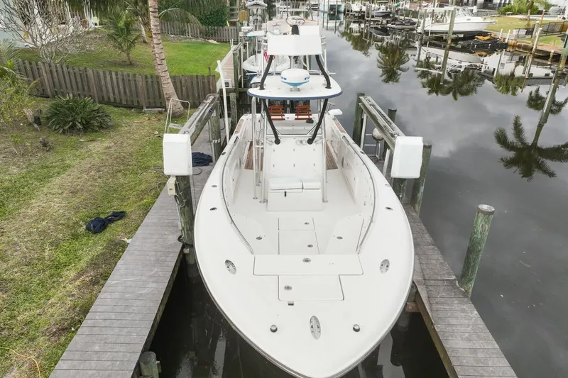Slide: The Image of 2007 Triton 351 CC boat docked in a serene canal setting. - 9