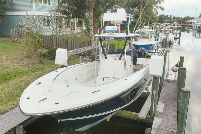 Slide: The Image of 2007 Triton 351 CC boat docked near waterfront home with palm trees. - 2