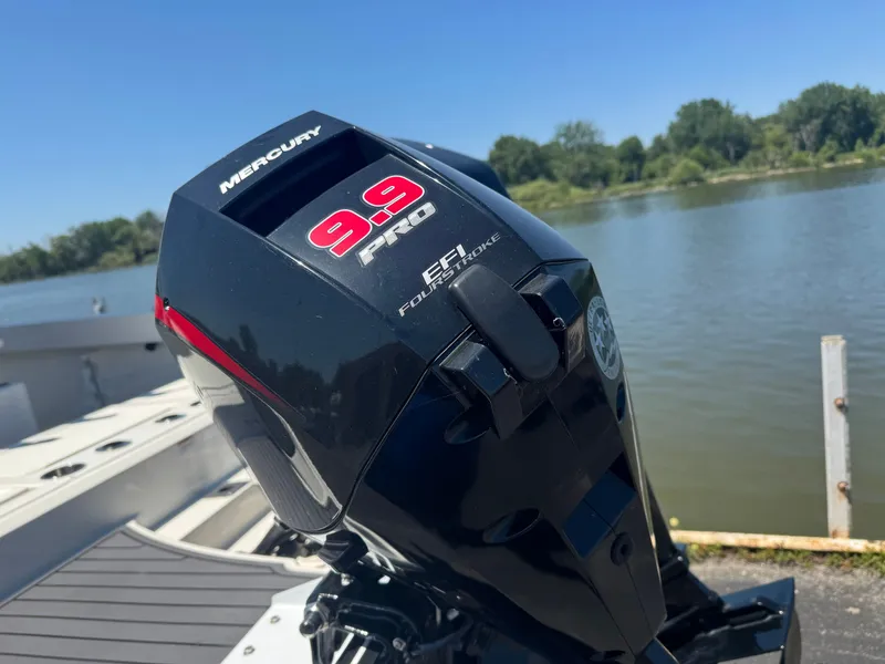 Slide: The Image of A Mercury 9.9 HP outboard motor on a Bayliner Trophy T22CC boat, near a calm water body. - 16