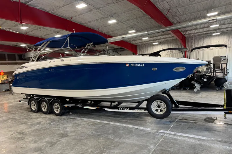 Slide: The Image of 2011 Cobalt boat with blue hull on trailer in indoor storage facility. - 1