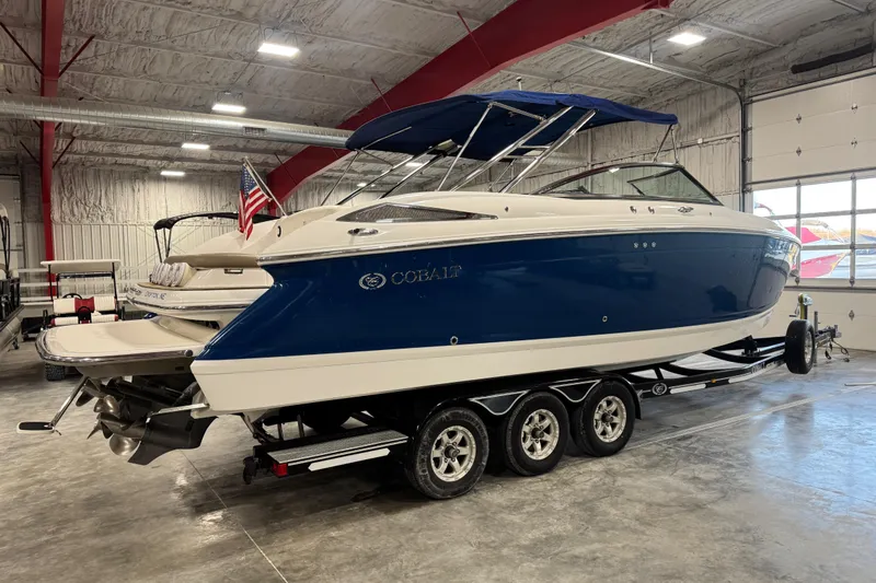 Slide: The Image of 2011 Cobalt boat with blue hull on trailer in indoor storage facility. - 3