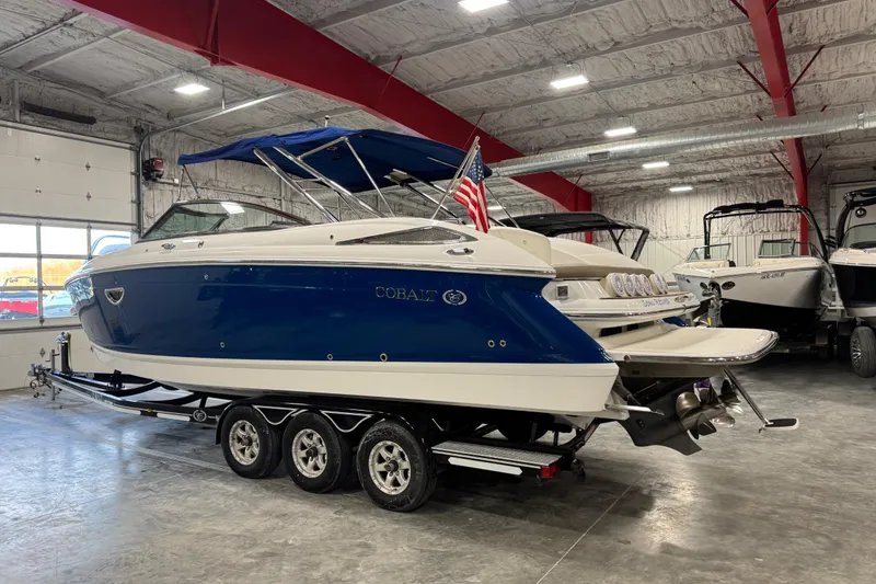Slide: The Image of 2011 Cobalt boat with blue hull on trailer in indoor showroom. - 4