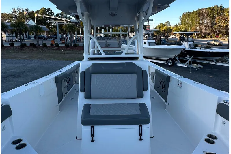 Slide: The Image of 2025 Sea Born SX281 Offshore boat interior with seating and console, parked outdoors. - 7
