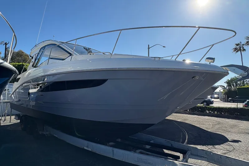 Slide: The Image of 2018 Sea Ray Sundancer 350 Coupe boat on trailer under clear blue sky. - 1