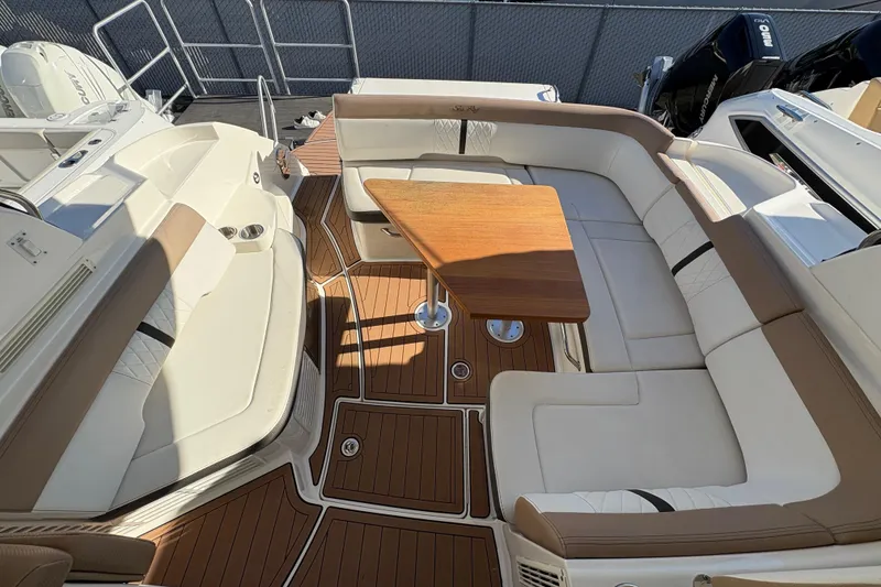 Slide: The Image of 2018 Sea Ray Sundancer 350 Coupe interior with elegant seating and wooden table. - 11