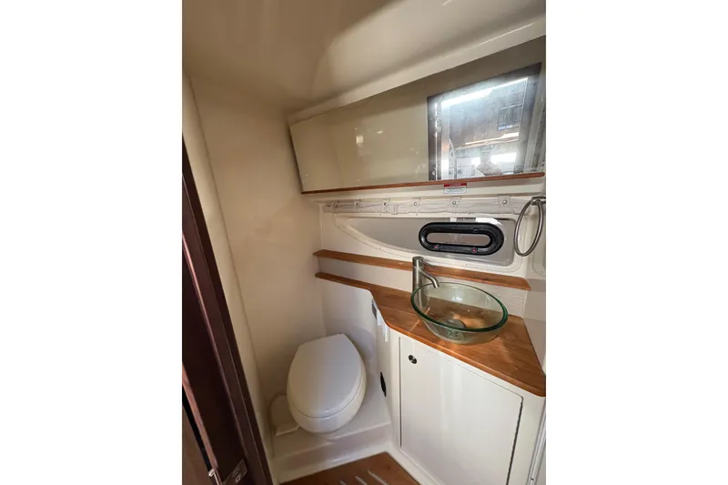 Slide: The Image of 2018 Sea Ray Sundancer 350 Coupe bathroom with modern sink and wooden accents. - 18