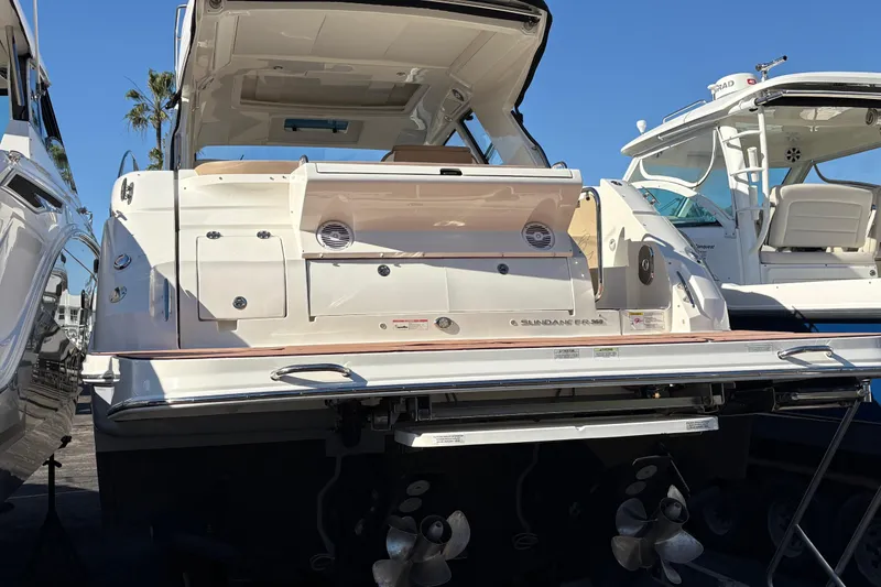 Slide: The Image of 2018 Sea Ray Sundancer 350 Coupe yacht, rear view, docked under clear blue sky. - 4