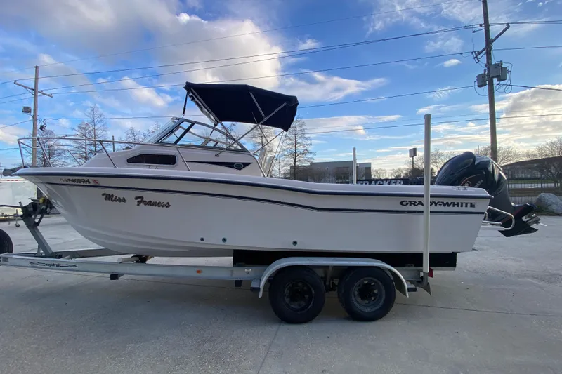 Slide: The Image of 1999 Grady-White Seafarer 228 boat on trailer under a partly cloudy sky. - 7