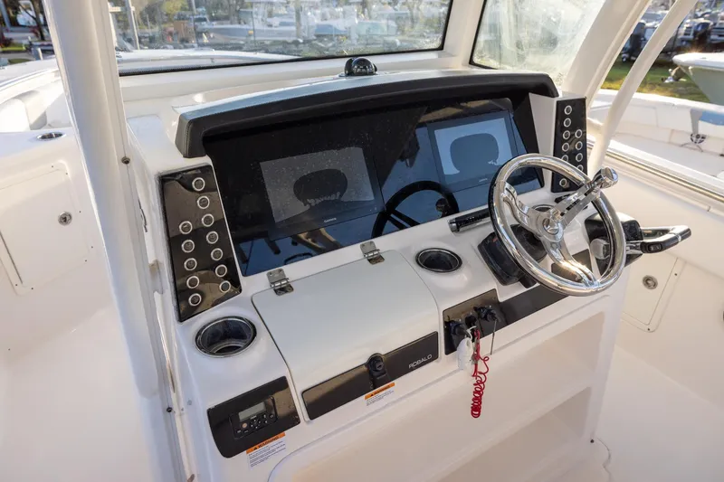 Slide: The Image of 2020 Robalo R302 Center Console helm with steering wheel and control panel. - 9