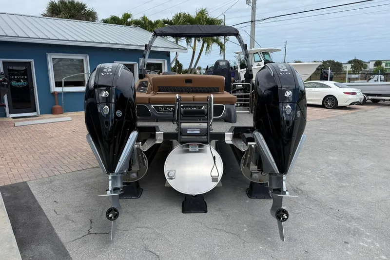 Slide: The Image of 2026 Bennington 27 QSBAT2 pontoon boat with dual outboard engines, parked outdoors. - 6