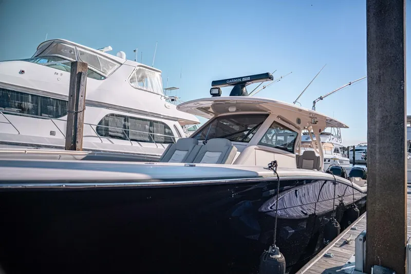 Slide: The Image of 2020 Scout 380 LXF luxury boat docked at marina under clear blue sky. - 14