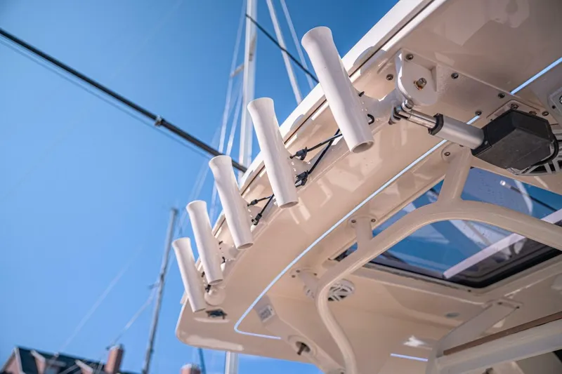 Slide: The Image of 2020 Scout 380 LXF boat with rod holders against clear blue sky. - 17